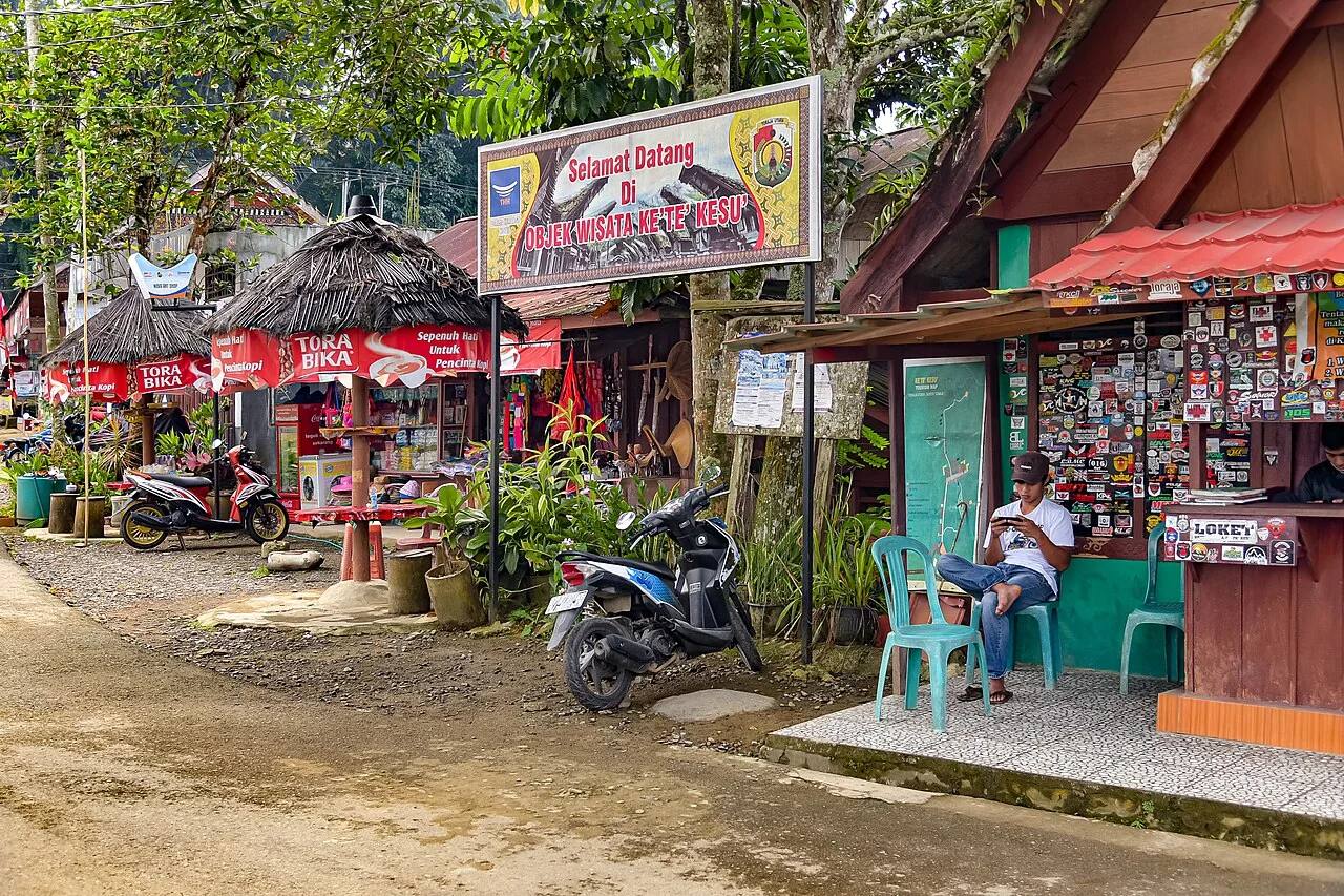 Shops and parked motorcycles outside Kete Kesu