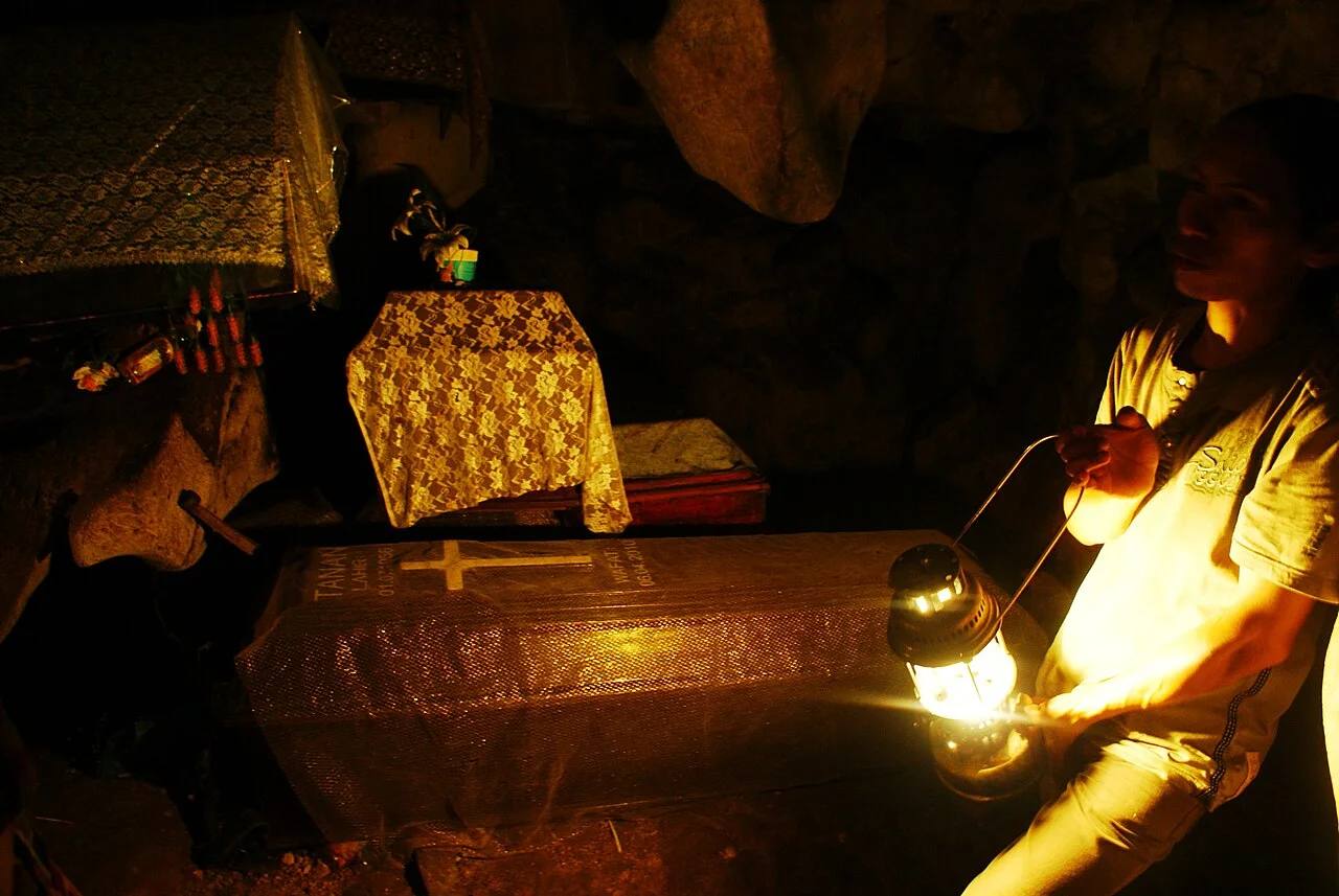 A lantern lighting coffins inside Londa burial cave