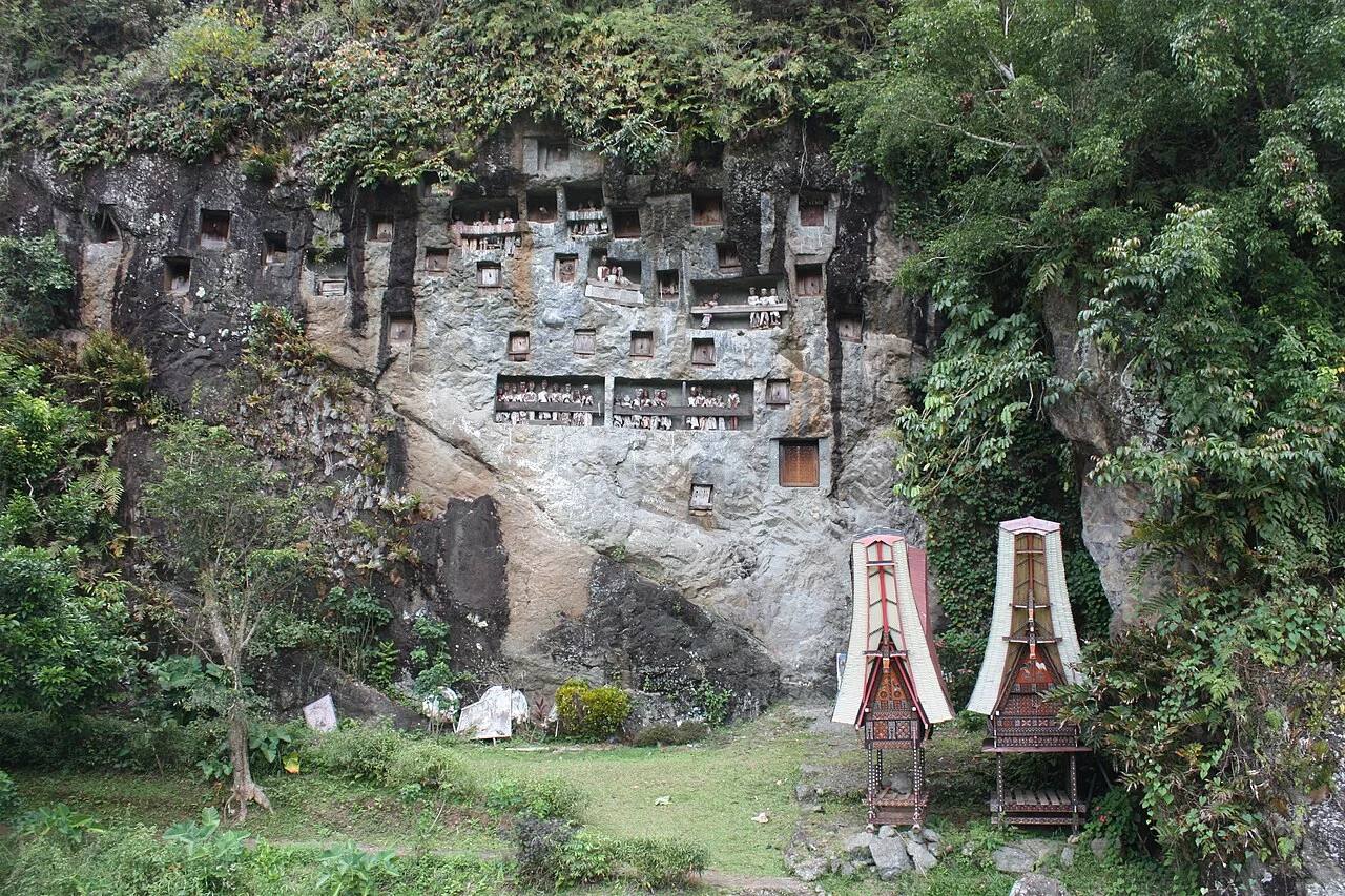 Lemo burial cliff with tau-tau galleries and small carved structures below