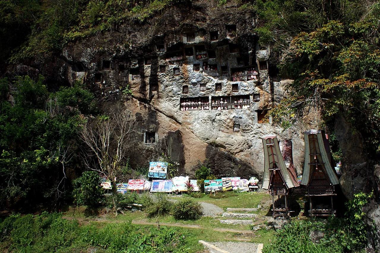 The rock burial galleries of Lemo above a grassy courtyard