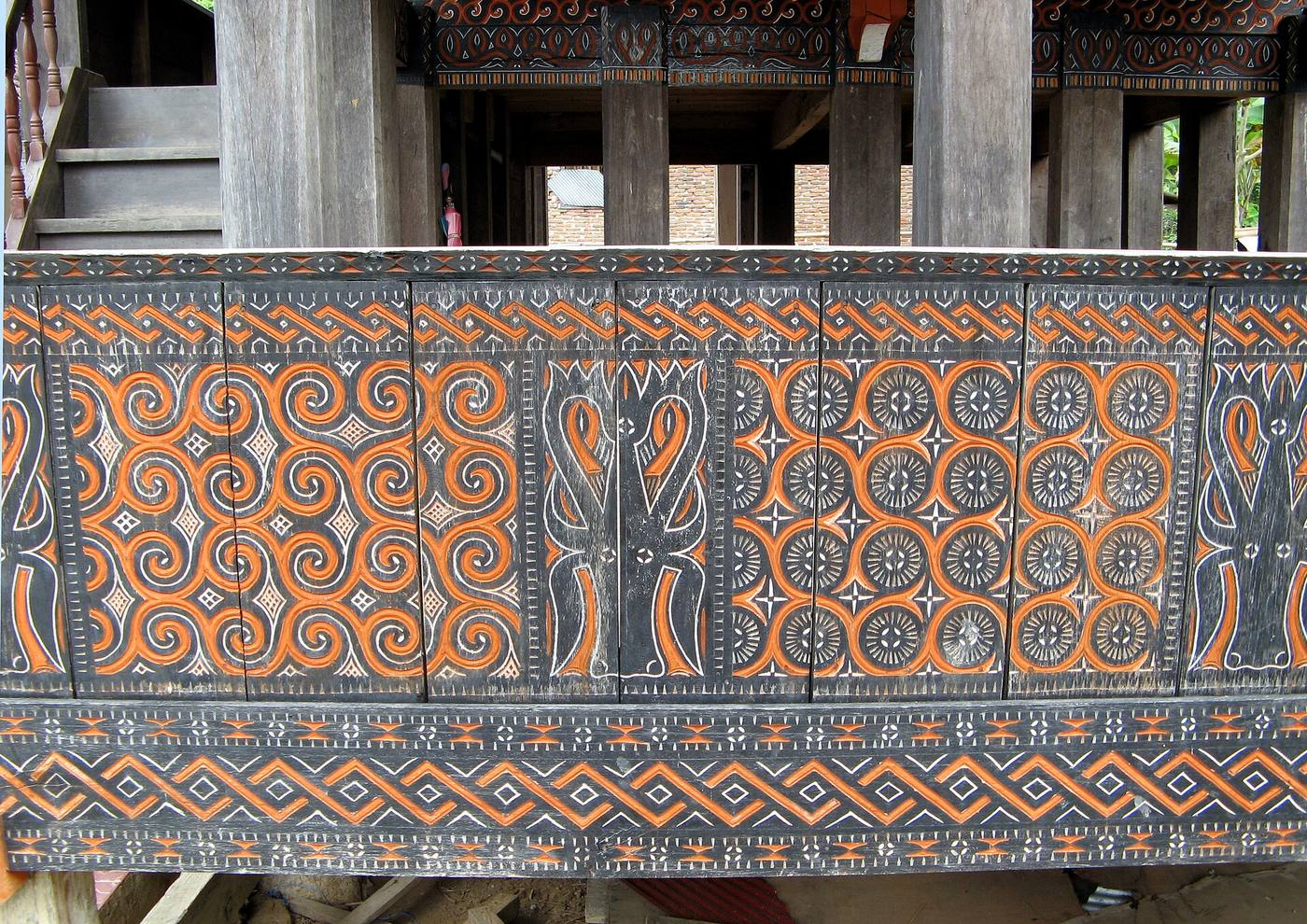 Orange and black geometric carving on a tongkonan at Palawa