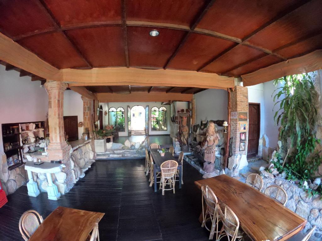 Covered dining area with wooden tables at Pias Poppies Hotel