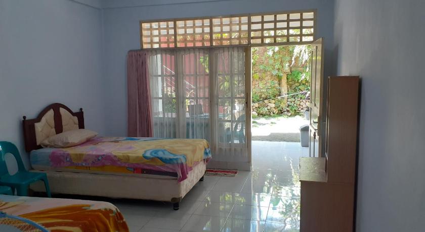 Bedroom at Riana’s Homestay opening towards a planted courtyard